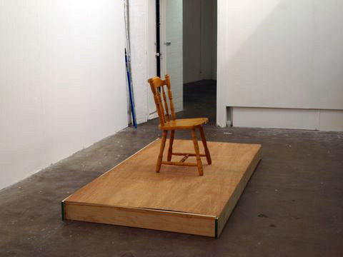 John G Boehme: <em>Dais (chaos with chair)</em>, similar recorded image projected over the destroyed chair and podium, 2010, performance shot, <em>CHAOS</em>; photo Jordan Hutchings; courtesy CHAOS” width=”400″><br /><br>
<div class=